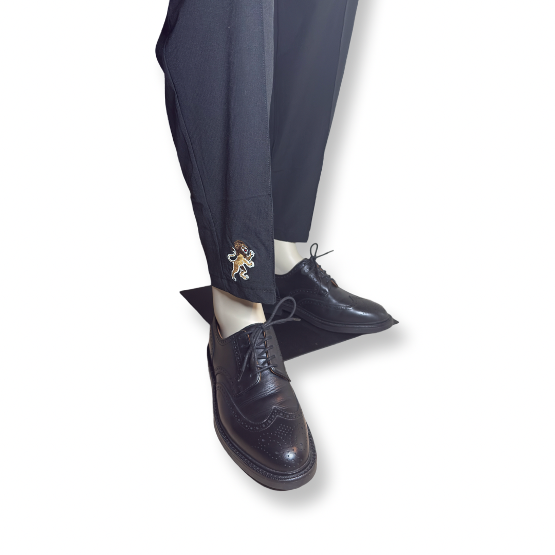 Lightweight cropped pants in Camouflage Green by Lion’s Tale Studios — modern fit, breathable nylon-spandex blend, bold lion emblem on the leg, branded buttons, unisex style for gym or smart casual wear. Lichtgewicht cropped broek in Camouflage Green van Lion’s Tale Studios — moderne pasvorm, ademende nylon-spandex mix, brullend leeuw-embleem op het been, merkknopen, uniseks stijl voor sport of casual chic.