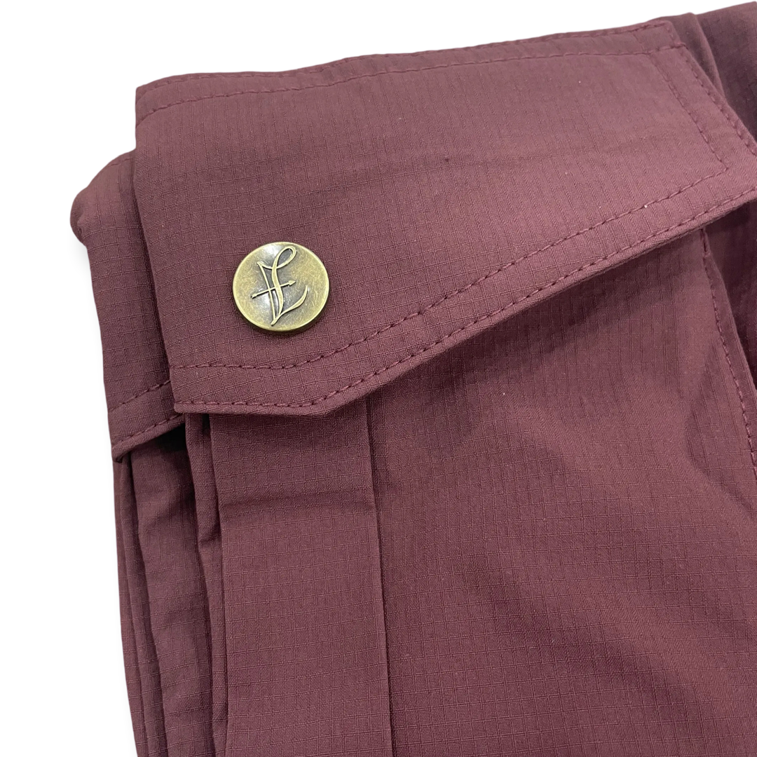 Lightweight cropped pants in Camouflage Green by Lion’s Tale Studios — modern fit, breathable nylon-spandex blend, bold lion emblem on the leg, branded buttons, unisex style for gym or smart casual wear. Lichtgewicht cropped broek in Camouflage Green van Lion’s Tale Studios — moderne pasvorm, ademende nylon-spandex mix, brullend leeuw-embleem op het been, merkknopen, uniseks stijl voor sport of casual chic.