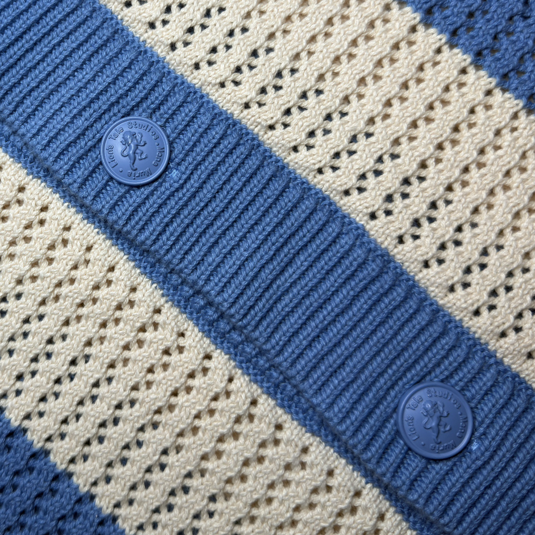 lion's tale studios knitwear knitted anti-logo no logo shirt light blue cream color button lion mena muria een voor allen voor een maluku molukken vertical stripes soft knit, breathable knitwear soft knit breathable knitwear cotton-blend quiet luxury, no-logo fashion, minimalist fashion Moluccan roots, heritage fashion, symbolic buttons unisex shirt, men’s knit shirt, women’s knitwear top cream and blue shirt, striped knit top, button-up knitwear designed in the Netherlands, Maluku inspired cardigan